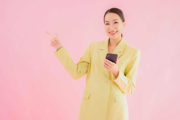 Retrato hermosa joven mujer de negocios asiática utiliza teléfono móvil inteligente con taza de café en color