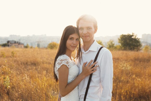 Retrato de la hermosa joven pareja sonriente en amor sol reflejado