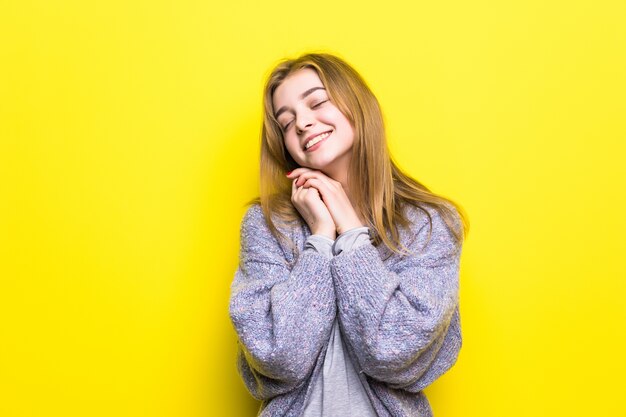 Retrato de una hermosa joven soñadora sonriendo mirando hacia arriba pensando soñando con la mano en la barbilla.