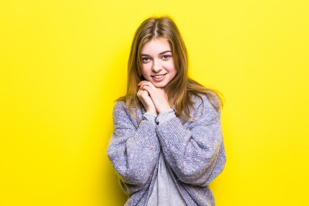 Retrato de una hermosa joven soñadora sonriendo mirando hacia arriba pensando soñando con la mano en la barbilla.