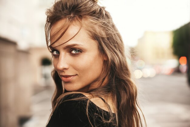 Retrato de la hermosa modelo adolescente linda rubia sin maquillaje en ropa hipster de verano posando en el fondo de la calle