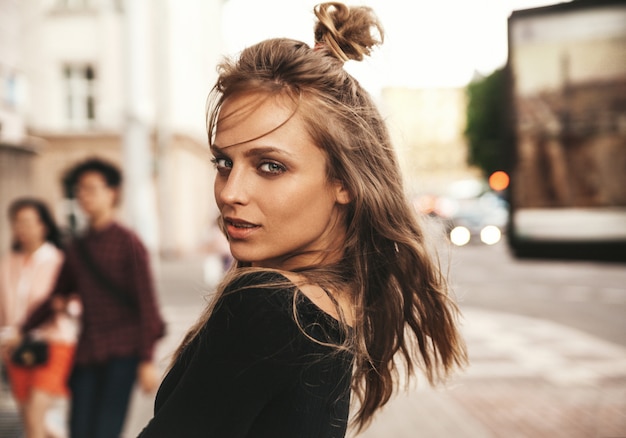 Retrato de la hermosa modelo adolescente linda rubia sin maquillaje en ropa hipster de verano posando en el fondo de la calle