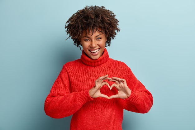 Retrato de hermosa modelo femenina hace gesto de corazón, dice ser mi San Valentín, demuestra signo de amor