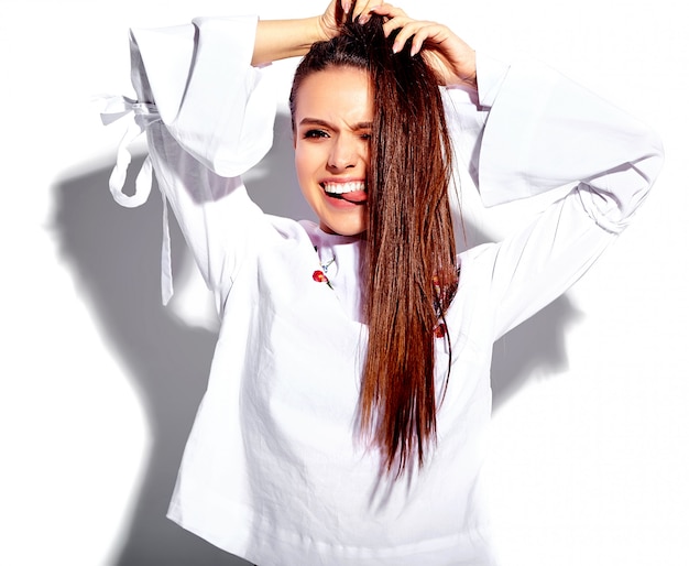 Retrato de la hermosa modelo de mujer morena caucásica sonriente en blusa blanca y elegantes jeans de verano con estampado de flores