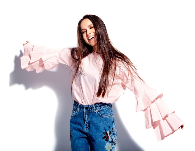 Foto gratuita retrato de la hermosa modelo de mujer morena caucásica sonriente en blusa rosa brillante y elegantes jeans de verano