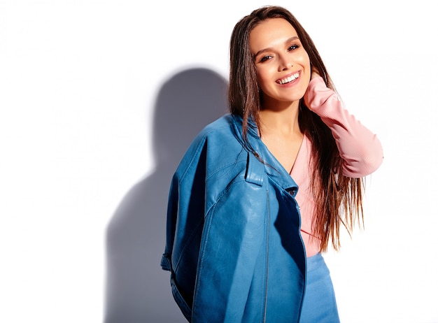 Retrato de la hermosa modelo de mujer morena caucásica sonriente en ropa elegante de verano rosa y azul brillante aislado sobre fondo blanco