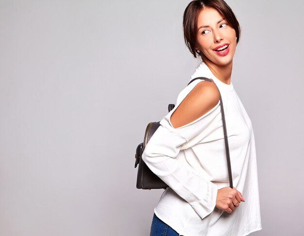 Retrato de la hermosa modelo de mujer morena linda sonriente en ropa casual de verano sin maquillaje aislado en gris