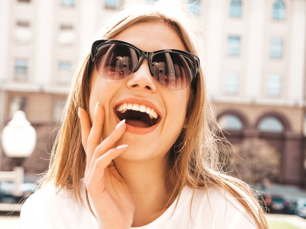 Retrato de la hermosa modelo rubia sonriente vestida con ropa hipster de verano.