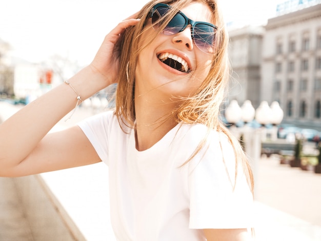 Retrato de la hermosa modelo rubia sonriente vestida con ropa hipster de verano.