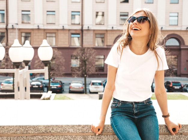 Retrato de la hermosa modelo rubia sonriente vestida con ropa hipster de verano.