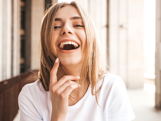 Retrato de la hermosa modelo rubia sonriente vestida con ropa hipster de verano.