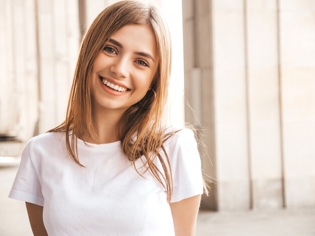 Retrato de la hermosa modelo rubia sonriente vestida con ropa hipster de verano.