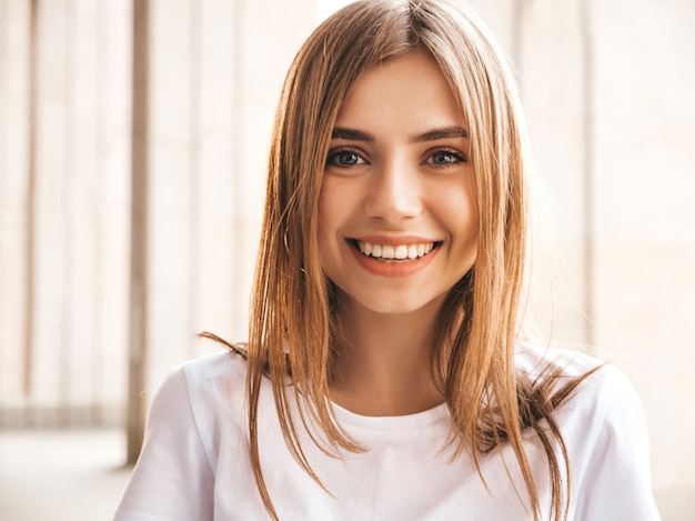 Retrato de la hermosa modelo rubia sonriente vestida con ropa hipster de verano.