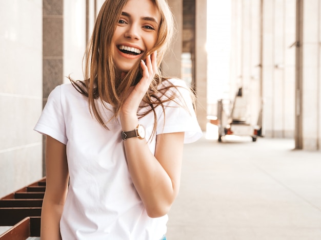 Retrato de la hermosa modelo rubia sonriente vestida con ropa hipster de verano.