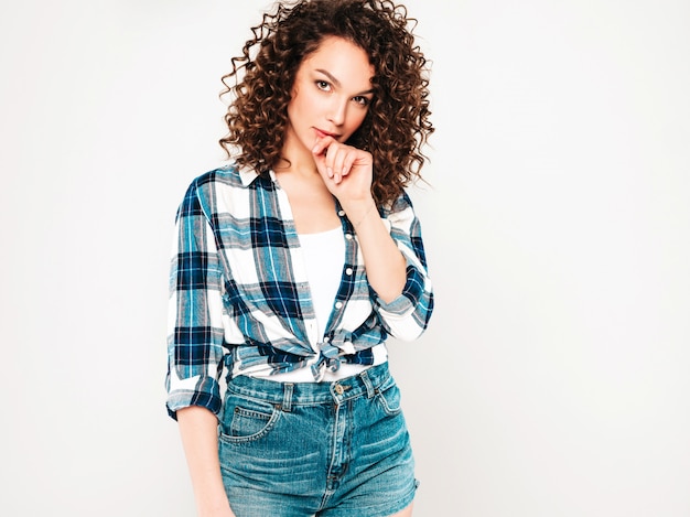 Foto gratuita retrato de hermosa modelo sonriente con peinado afro rizos vestido con ropa hipster de verano. chica despreocupada sexy posando en estudio sobre fondo gris. mujer divertida y positiva de moda