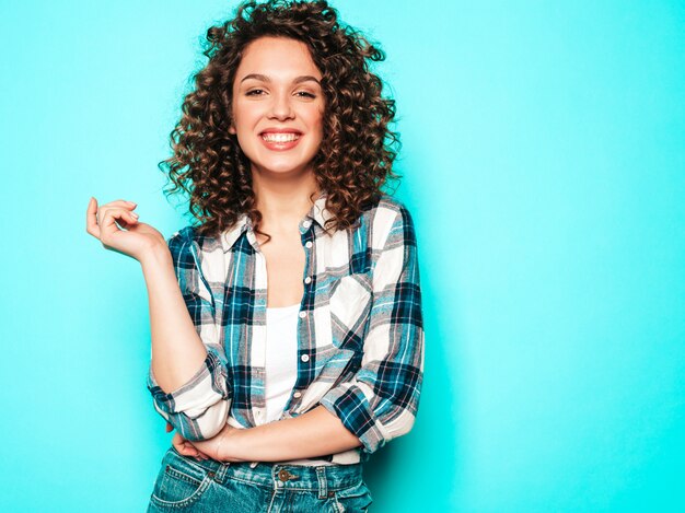 Retrato de hermosa modelo sonriente con peinado afro rizos vestido con ropa hipster de verano. Mujer divertida y positiva de moda