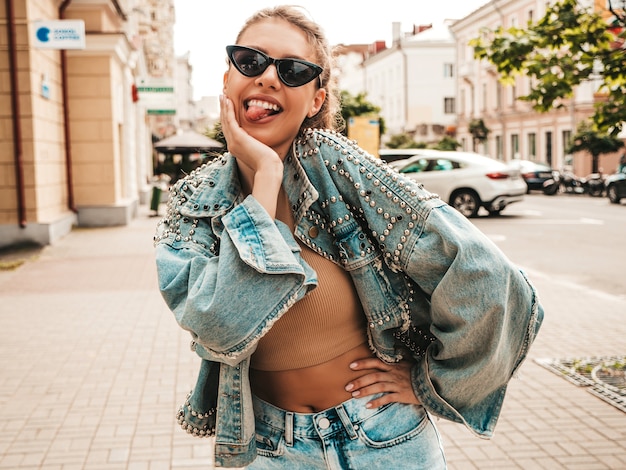 Retrato de hermosa modelo sonriente vestida con chaqueta de jeans hipster de verano