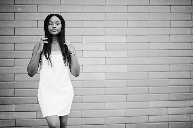 Retrato de una hermosa mujer afroamericana negra perfecta posando contra una pared de ladrillos en el fondo Foto en blanco y negro