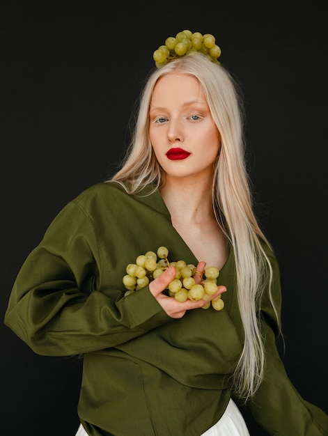 Retrato de hermosa mujer albina con uvas