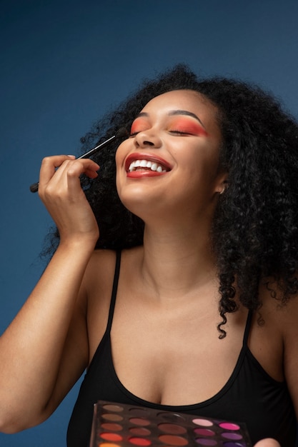 Retrato de una hermosa mujer aplicando maquillaje con un pincel de maquillaje
