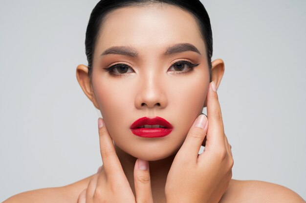 Retrato de hermosa mujer asiática con cabello negro y labios rojos