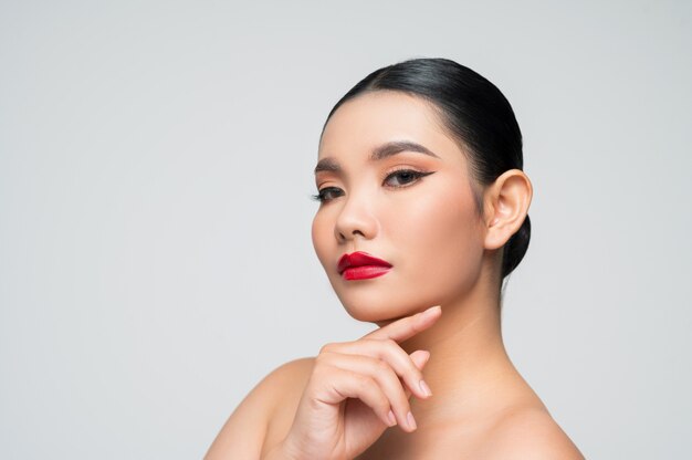 Retrato de hermosa mujer asiática con cabello negro y labios rojos