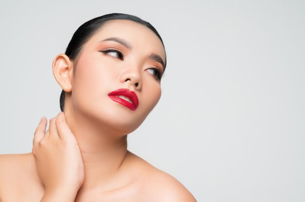 Retrato de hermosa mujer asiática con cabello negro y labios rojos