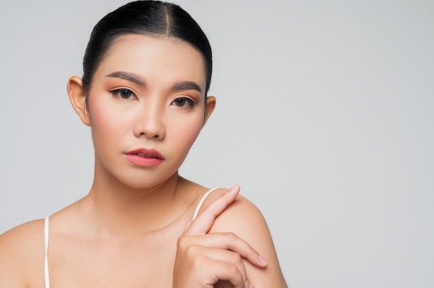 Retrato de hermosa mujer asiática con cabello negro y labios rosados