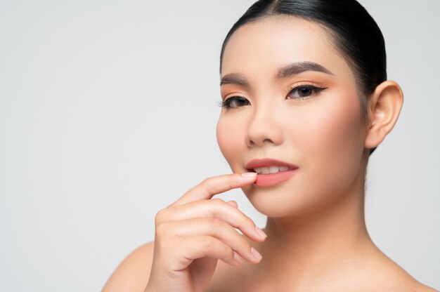 Retrato de hermosa mujer asiática con cabello negro y labios rosados