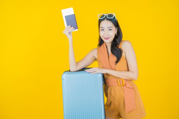 Retrato de hermosa mujer asiática joven con bolsa de equipaje y pasaporte listo para viajar