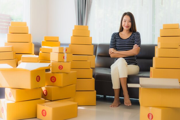 Retrato de hermosa mujer asiática joven con cajas de paquetería de cartón