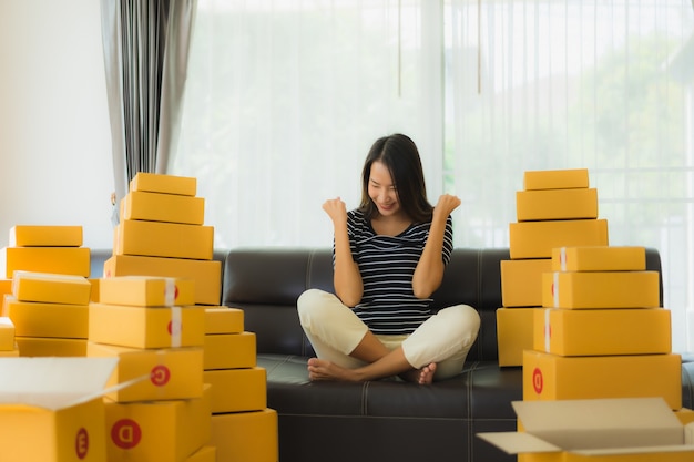 Retrato de hermosa mujer asiática joven con cajas de paquetería de cartón