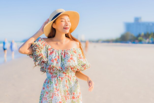 Retrato hermosa mujer asiática joven feliz sonrisa relajarse alrededor de la playa tropical mar océano