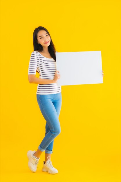 Retrato hermosa mujer asiática joven muestra signo de cartelera blanca vacía