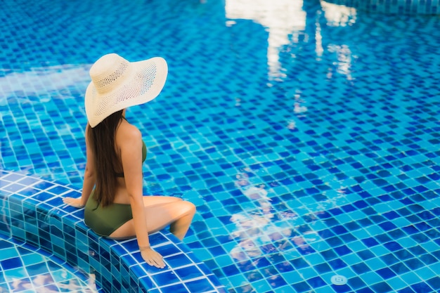 Retrato hermosa mujer asiática joven relajarse alrededor de la piscina en el hotel resort