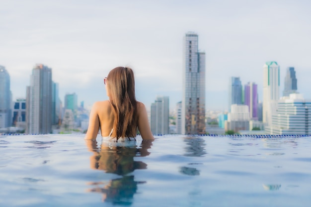 Retrato hermosa mujer asiática joven relajarse feliz sonrisa ocio alrededor de la piscina al aire libre