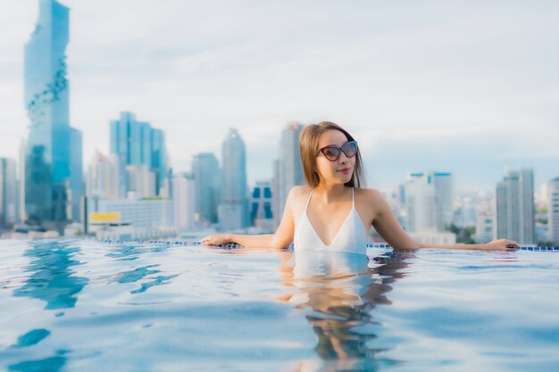 Retrato hermosa mujer asiática joven relajarse feliz sonrisa ocio alrededor de la piscina al aire libre