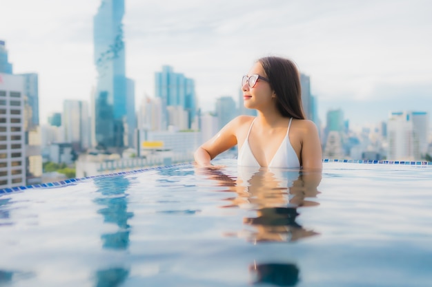 Retrato hermosa mujer asiática joven relajarse feliz sonrisa ocio alrededor de la piscina al aire libre