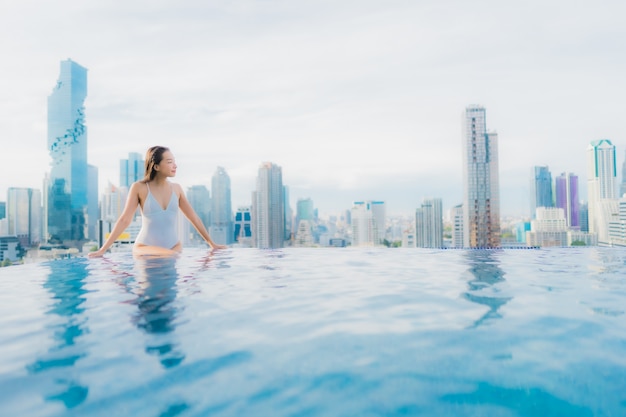 Retrato hermosa mujer asiática joven relajarse feliz sonrisa ocio alrededor de la piscina al aire libre