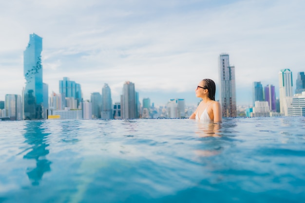 Retrato hermosa mujer asiática joven relajarse feliz sonrisa ocio alrededor de la piscina al aire libre