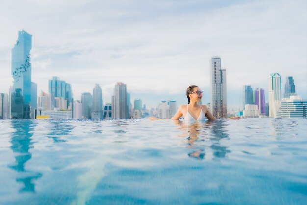 Retrato hermosa mujer asiática joven relajarse feliz sonrisa ocio alrededor de la piscina al aire libre