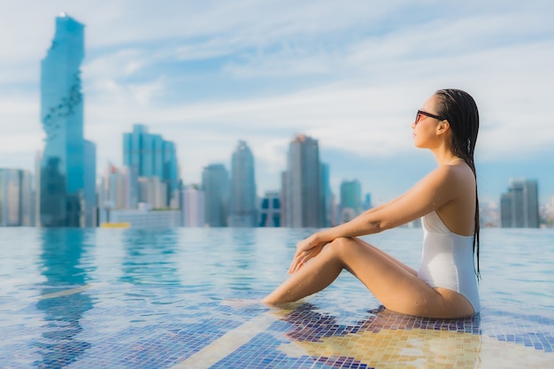 Retrato hermosa mujer asiática joven relajarse feliz sonrisa ocio alrededor de la piscina al aire libre