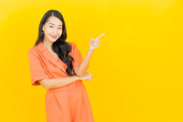 Retrato hermosa mujer asiática joven sonrisa con acción en amarillo