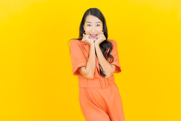 Retrato hermosa mujer asiática joven sonrisa con acción en amarillo