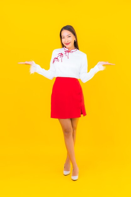 Retrato hermosa mujer asiática joven sonrisa en acción en amarillo