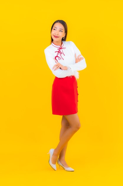 Retrato hermosa mujer asiática joven sonrisa en acción en amarillo