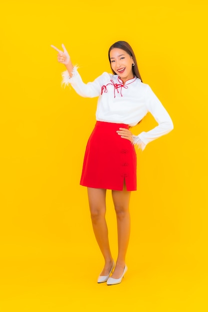 Retrato hermosa mujer asiática joven sonrisa en acción en amarillo