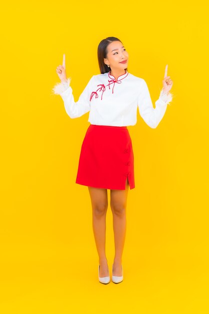 Retrato hermosa mujer asiática joven sonrisa en acción en amarillo