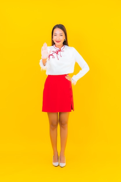 Retrato hermosa mujer asiática joven sonrisa en acción en amarillo