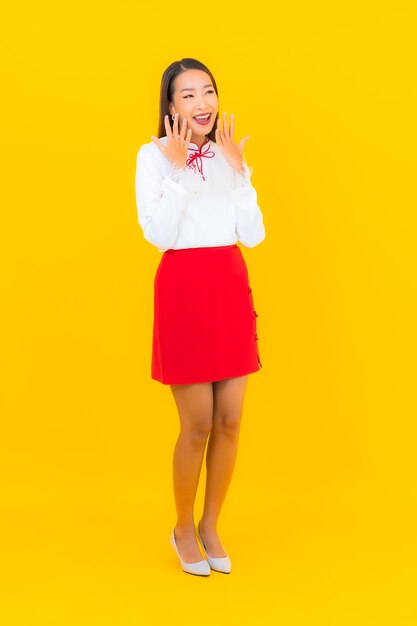 Retrato hermosa mujer asiática joven sonrisa en acción en amarillo